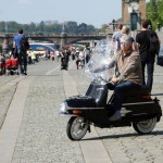 L’imprenditore Neil Smith in sella a un Čezeta sul lungofiume praghese / The entrepreneur Neil Smith riding a Čezeta on Prague’s riverside © Čezeta Motors